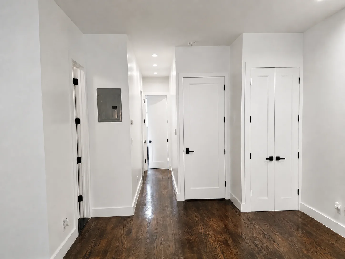 Finished interior with dark wood flooring, painted walls, doors and detailed trim